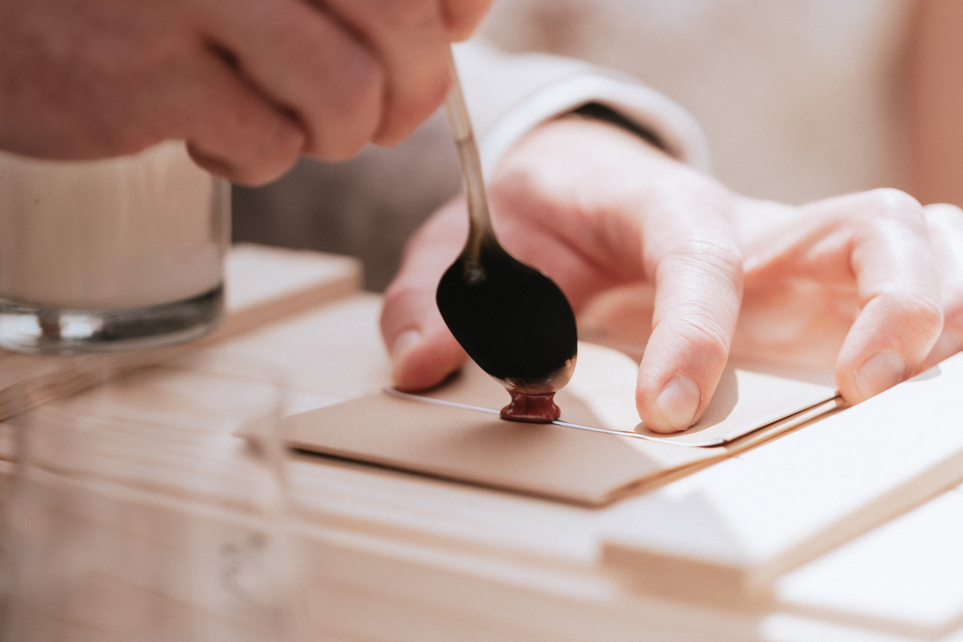 A hand sealing a card with wax during a wedding ritual